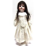 AN ARMAND MARSEILLE BISQUE SOCKET HEAD DOLL with a long dark brown wig, sleeping brown glass eyes,