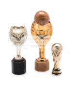 Three miniature replicas of FIFA World Cup trophies,