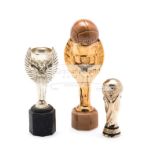 Three miniature replicas of FIFA World Cup trophies,