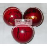 A trio of red leather cricket balls signed by West Indies cricketing legends Clive Lloyd,