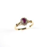 9 ct yellow gold ruby ring. Set with an oval cut ruby in a single cut diamond set surround.