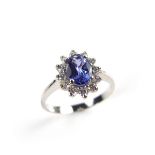 14 ct white gold tanzanite and diamond cluster ring. The oval cut tanzanite weighing approx. 0.