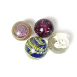 A group of four large glass marbles, 19th century and later.