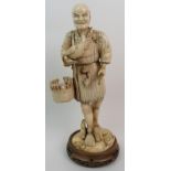 A large Japanese sectional ivory okimono with a fisherman holding a tied cormorant to his wrist, (