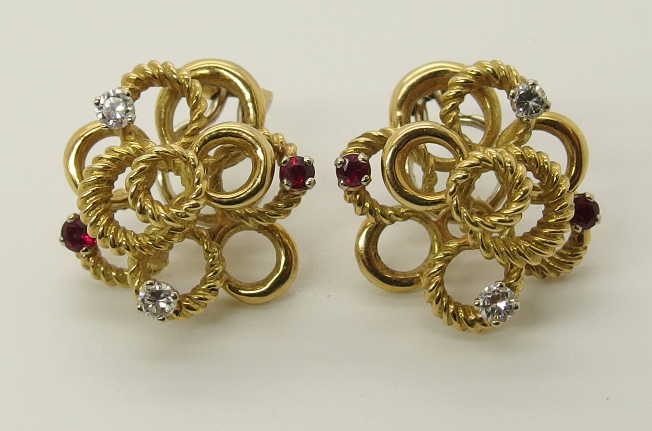 A pair of 18ct gold ruby and diamond earrings of interlinked circle design, with clip and post