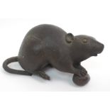 A Japanese bronze model of a rat crouching and holding a nut, signed, (damage to tail), 17cm long