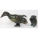 An Inuit hardstone carving of a seal balancing on one flipper, 24cm high x 36cm wide and a carving