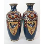 A pair of Chinese cloisonne baluster vases decorated with phoenix and panels of foliage, 30cm