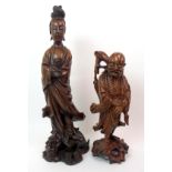 A Chinese hardwood carving of Guanyin standing on a grotesque beast and holding a scroll, 55cm