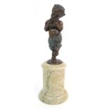 A BRONZE STATUE OF A SATYR playing pan pipes, upon a cylindrical onyx base, signed Bois to base,