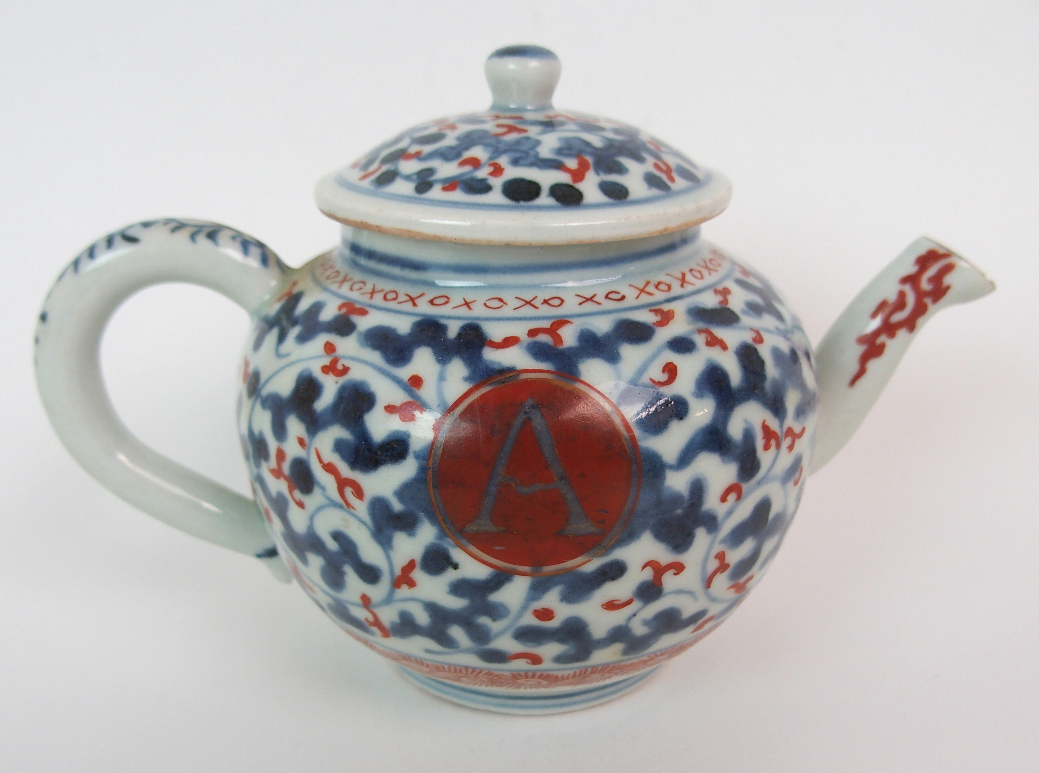 A CHINESE EXPORT GLOBULAR TEAPOT AND COVER painted with blue and iron red vermiculated ground and