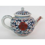 A CHINESE EXPORT GLOBULAR TEAPOT AND COVER painted with blue and iron red vermiculated ground and