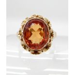 A CONTINENTAL YELLOW METAL RETRO RING set with a synthetic padparadscha sapphire, stamped with