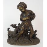 A BRONZE FIGURE OF A BOY HOLDING A PUPPY modelled on a naturalistic base and with a dog holding onto