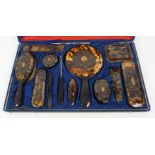 A CHINESE TORTOISESHELL BRUSH SET comprising; hand mirror, clothes brushes, hair brushes, button