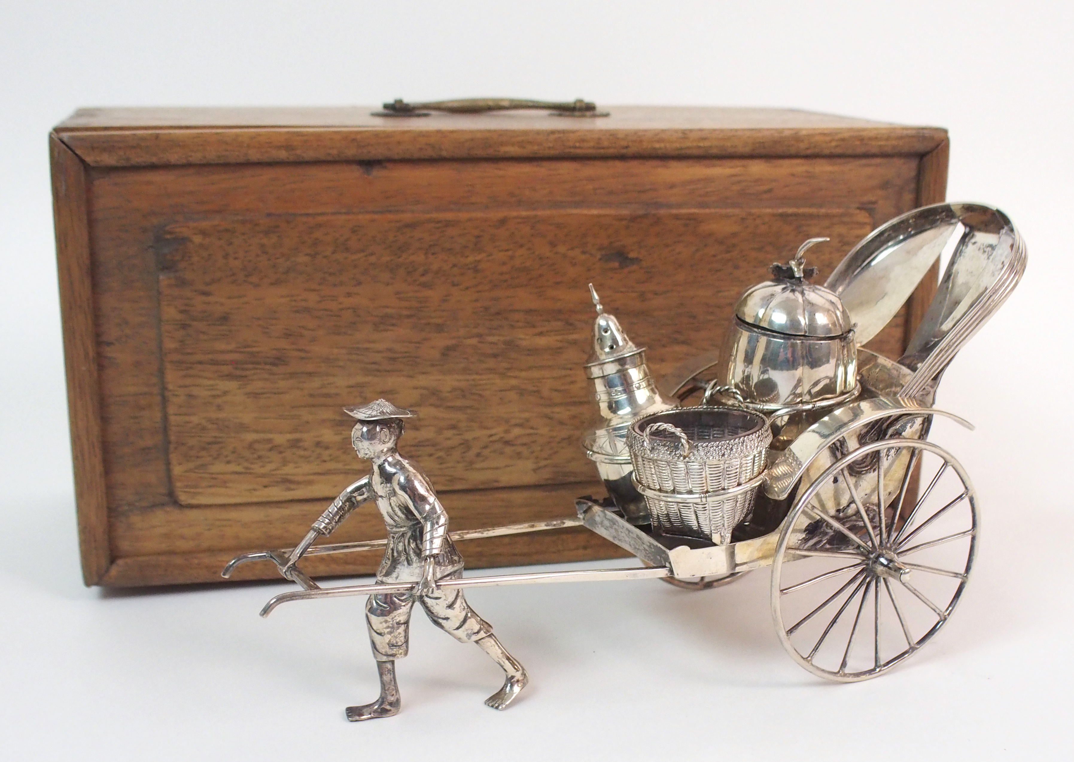 A CHINESE SILVER RICKSHAW CRUET of traditional type with salt, pepper and mustard pot, the carriage,