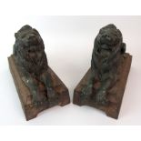 A PAIR OF CAST METAL LIONS with verdigris patina, on metal bases with cement infill, 31cm long (2)