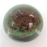 A MONART GLASS PAPERWEIGHT the clear glass dome with green and aventurine base, partial paper