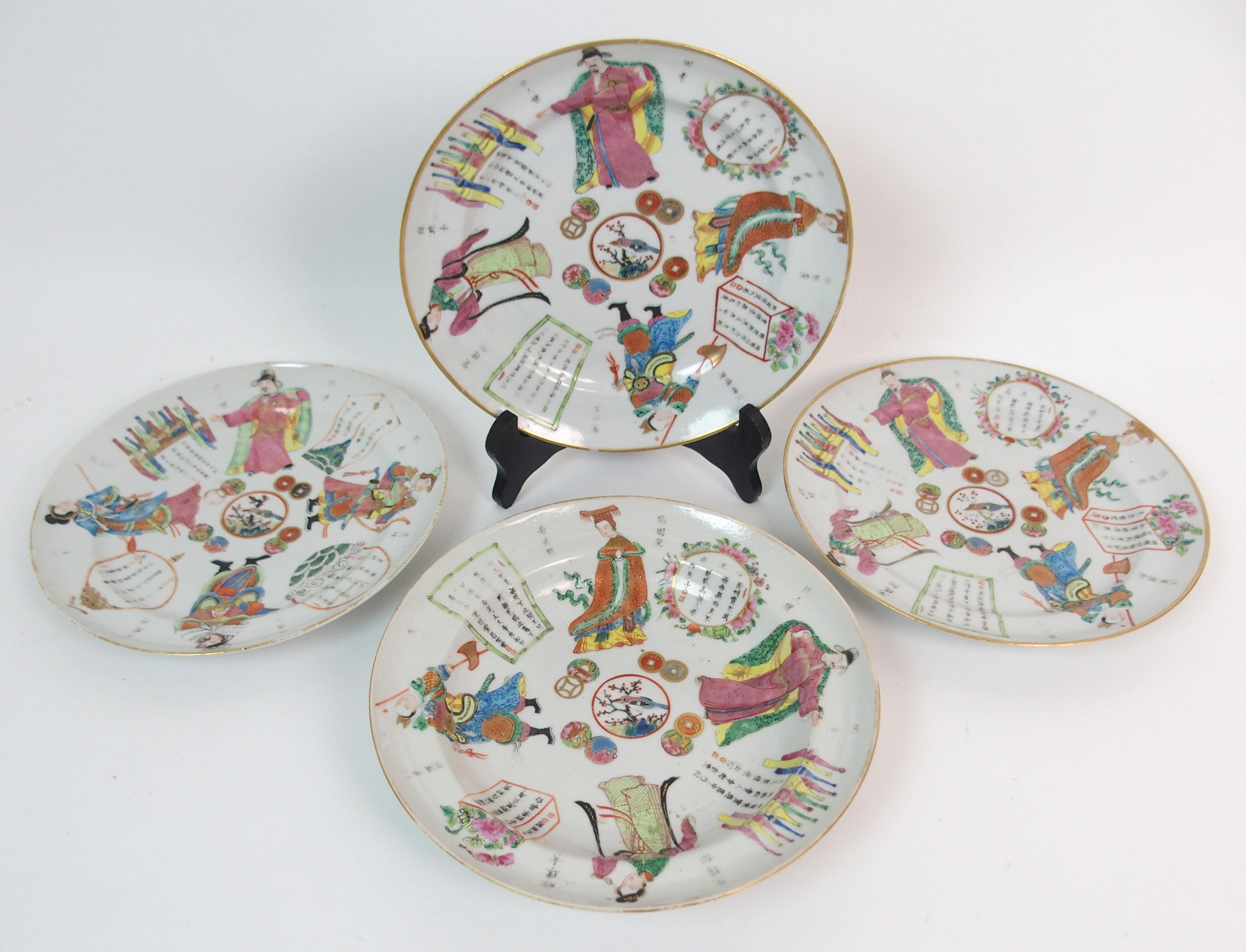 FOUR CANTON PLATES painted with figures, calligraphy, coins and birds within gilt rims (one with rim