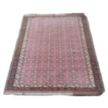 AN EASTERN PINK GROUND RUG with allover design and geometric design border, 180cm x 142cm