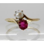 A RUBY AND PEARL RING mounted in yellow metal, in a twist design. Finger size J1/2, weight 1.7gms