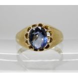 A YELLOW METAL SAPPHIRE SET RING in gypsy style setting, dimensions of the sapphire 7.5mm x 6.1mm