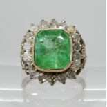 AN EMERALD AND DIAMOND RING set throughout in white and yellow metal, with diamond set fleur de