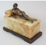 AN ART DECO SPELTER FIGURE of a reclining naked female on an onyx box shaped plinth and wooden base,