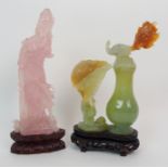 A CHINESE ROSE QUARTZ FIGURE OF GUANYIN standing on lily pads (some chips), 19cm high, wood stand