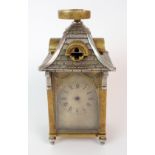 A FRENCH BRASS AND GLASS CARRIAGE CLOCK modelled with a silver plated tiled sloping roof with