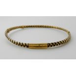 *WITHDRAWN* AN ELEPHANT HAIR BANGLE with decorative yellow metal design holding the hair in place