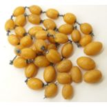 A COLLECTION OF AMBER COLOURED BEADS some are loose, some are mounted with white metal wires and end