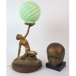 AN ART DECO LADY LAMP modelled semi-clad holding aloft a green glass globe, upon onyx base and