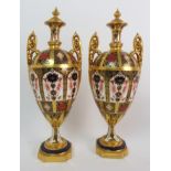 A PAIR OF ROYAL CROWN DERBY URNS AND COVERS each with twin handles, 1128 pattern, date unknown, 30cm