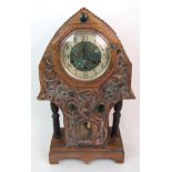 AN ARTS AND CRAFTS STYLE CLOCK the case covered in copper and with relief decoration of scrolling