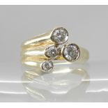 A 9CT GOLD FOUR DIAMOND DRESS RING in a spray design the combined estimated approximate total of the