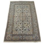 A CREAM GROUND KASHAN RUG with floral design medallion and floral palmette borders, 317cm x 200cm
