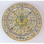 A LARGE ITALIAN MAJOLICA CHARGER decorated with cherubs, mythical beasts and swags surrounding a