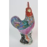 A CHINESE EXPORT MODEL OF A COCKEREL with red comb and coloured plumage on a rockwork base, 22cm