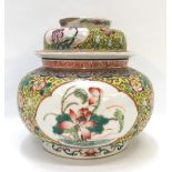 A Chinese famille rose jar and cover, decorated with peonies and with a dragon to the lid, 15.5cm