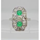 An 18ct white gold diamond and emerald plaque ring, the two step cut emeralds measure 3.8mm x 3.