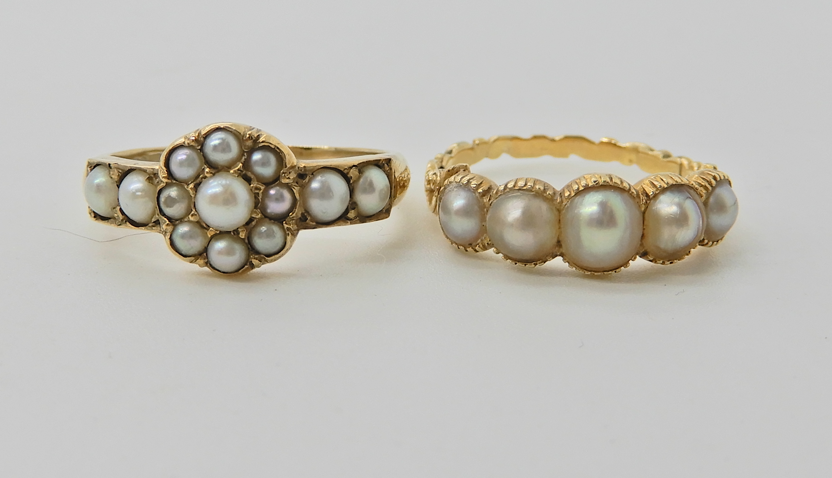 A bright yellow metal five pearl set ring with scrolled shoulders. Finger size O1/2, weight 3.