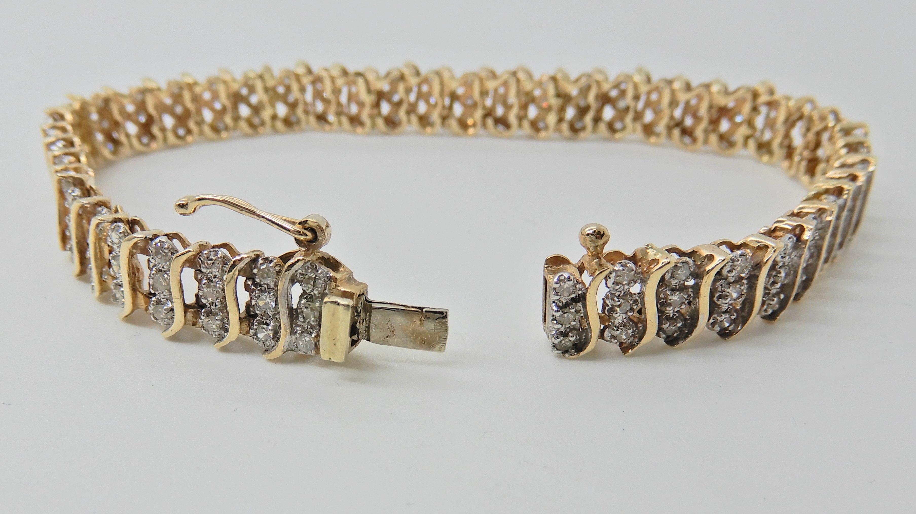 A 9ct gold diamond set bracelet, with 'S' shaped links, stamped 375 and the diamond content is - Image 2 of 4