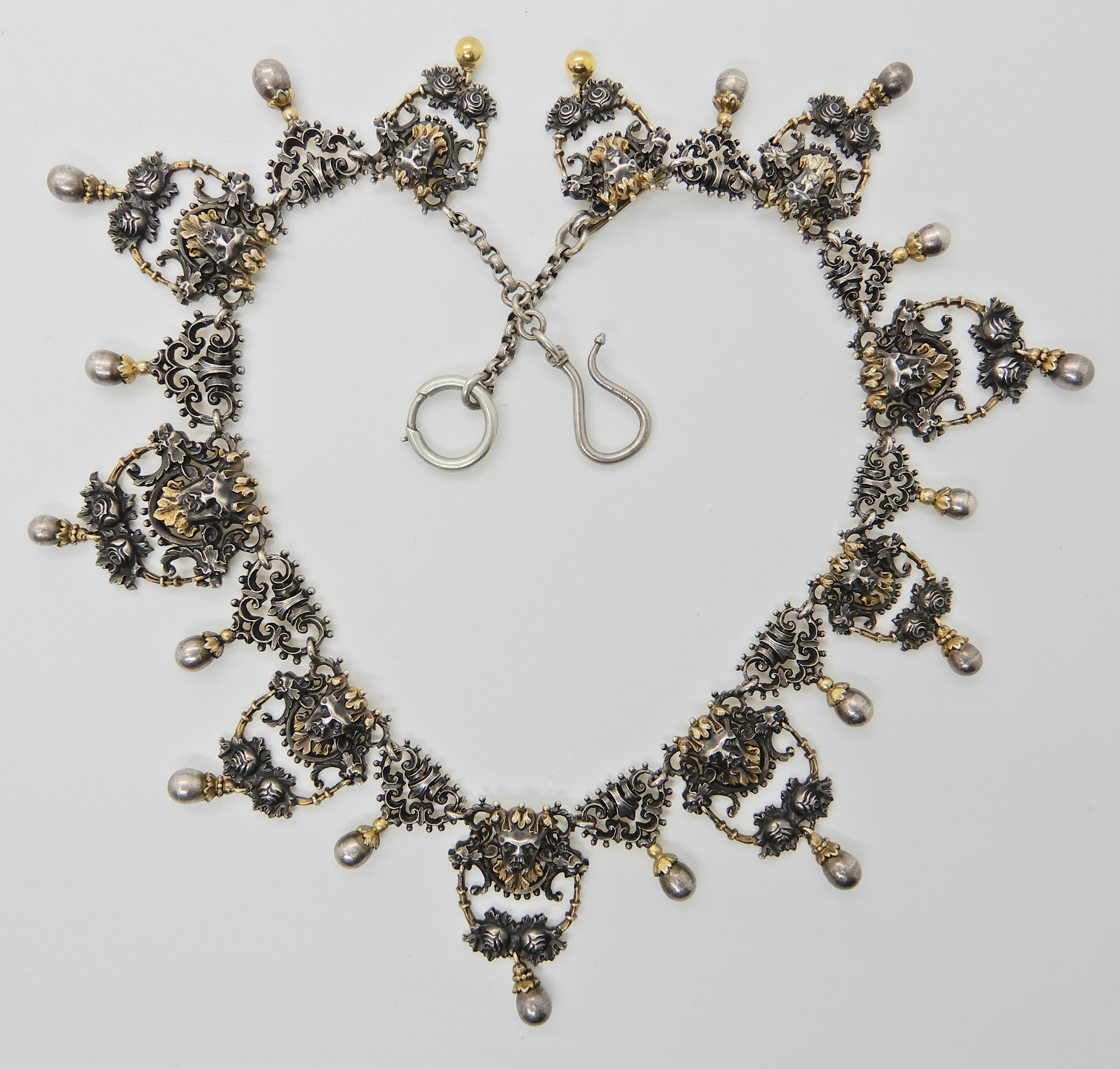 A gilded white metal Gothic design necklace with lion heads and 'Pan' grotesque masks and roses,