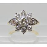 An 18ct yellow and white gold diamond cluster ring of round brilliant cut diamonds and pear cut