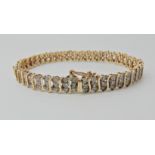 A 9ct gold diamond set bracelet, with 'S' shaped links, stamped 375 and the diamond content is