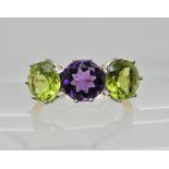 An 18ct gold and platinum peridot and amethyst three stone ring, Finger size N1/2 weight 4.1gms