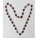 A 9ct gold necklace set with thirty amethysts of good deep purple colour in cut back claw