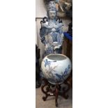 A large Chinese blue and white pottery figure of a warrior and a fish bowl on wooden stand Gilbert