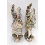 A pair of continental figures of a couple, holding flower garlands, 41cm high (damage and